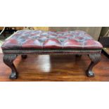 A leather button upholstered stool with leaf capped legs and claw and ball feet