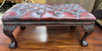 A leather button upholstered stool with leaf capped legs and claw and ball feet