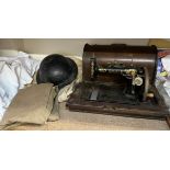 An Atlas sewing machine together with a military tin helmet,