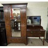A 20th century mahogany wardrobe with an egg and dart moulded cornice above a single mirrored door