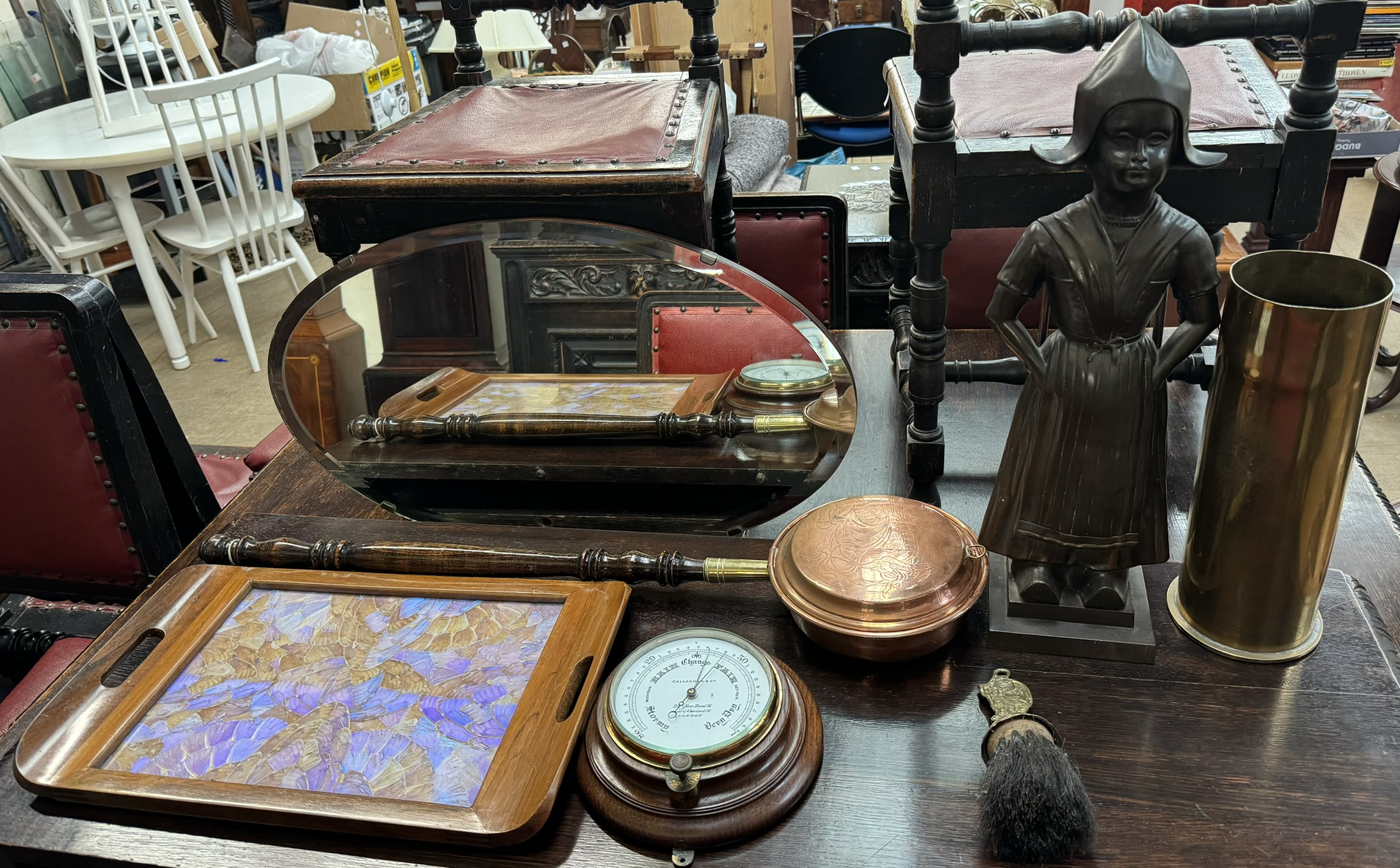 An oval wall mirror together with a butterfly wing tray, barometer, shell case,