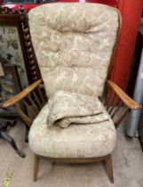 A mid 20th century elbow chair with stick back and sides on tapering legs CONDITION