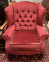 An upholstered wing back elbow chair