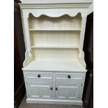 A cream painted pine dresser with a moulded cornice and two shelves the base with two drawers and