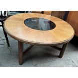 A G-Plan teak coffee table of circular form with a smoked glass insert on round legs
