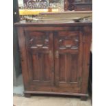 An oak side cabinet with a rectangular top above a pair of doors on square legs together with a