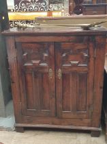 An oak side cabinet with a rectangular top above a pair of doors on square legs together with a