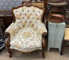 An upholstered library chair with a carved back, arms and legs together with a filing cabinet,