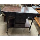 An Edwardian mahogany dressing table with a rectangular top above four drawers and shelves on