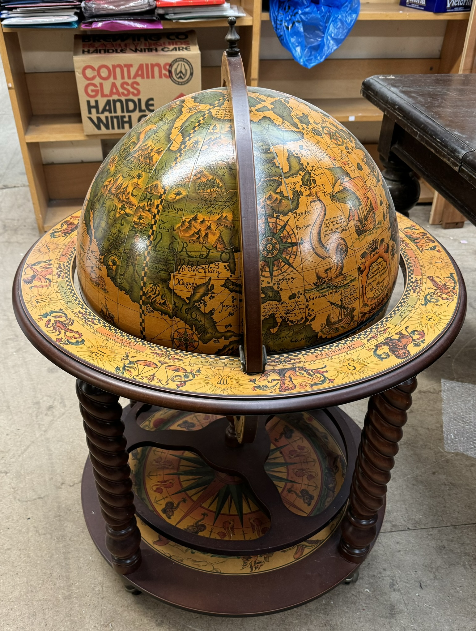 A globe drinks trolley with a hinged top and sectioned interior