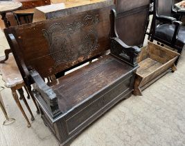 An oak monks bench with lion carved arms together with a child's cradle,