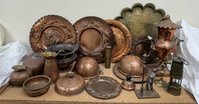 Copper chargers embossed with flowers, leaves a shield together with copper dish covers,