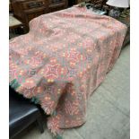 A Welsh blanket with a pink ground with green yellow and white geometric patterns
