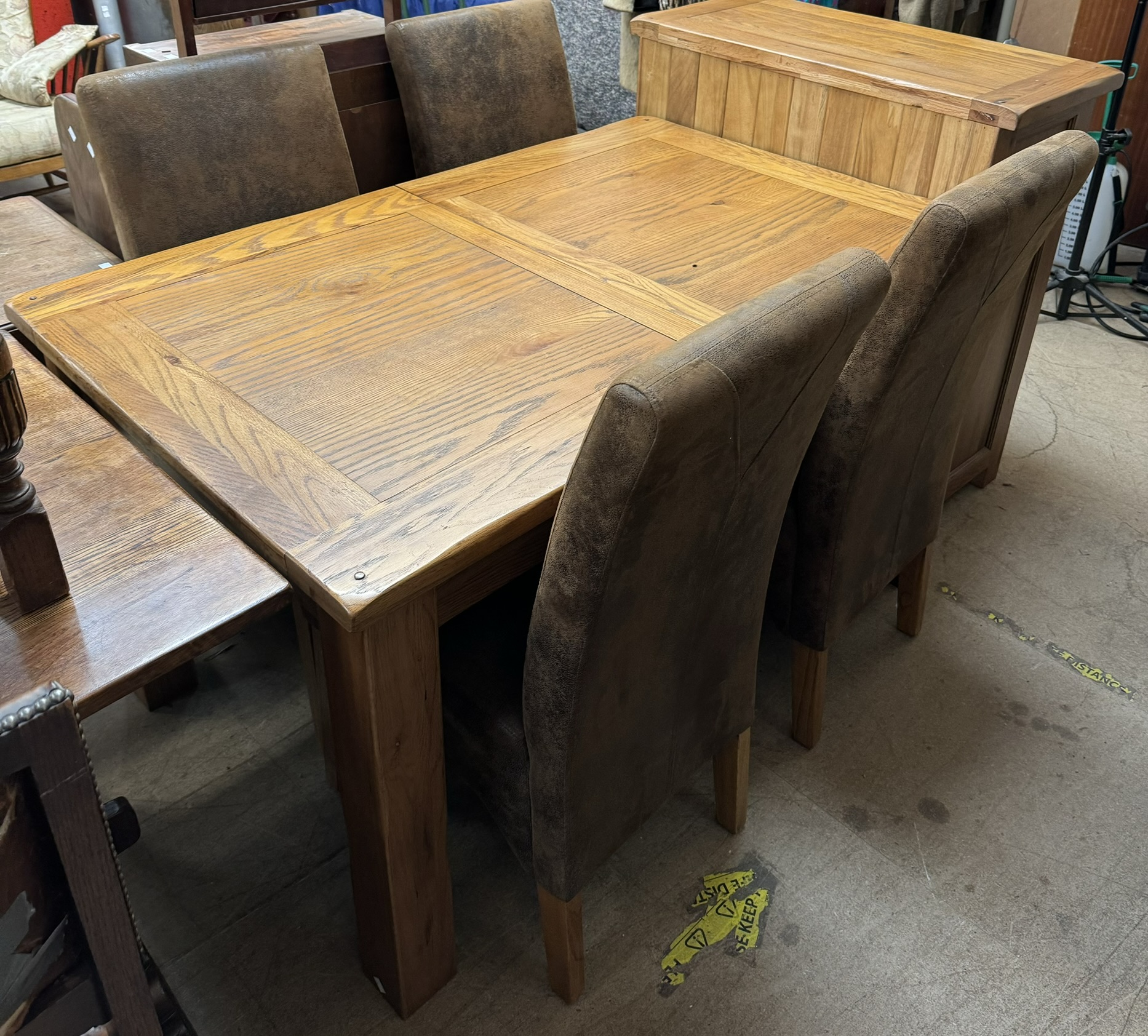 A modern oak dining table of rectangular form on square legs together with a set of four leather