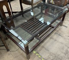 A modern coffee table with a glass top and shelves together with an oak kneeling stool