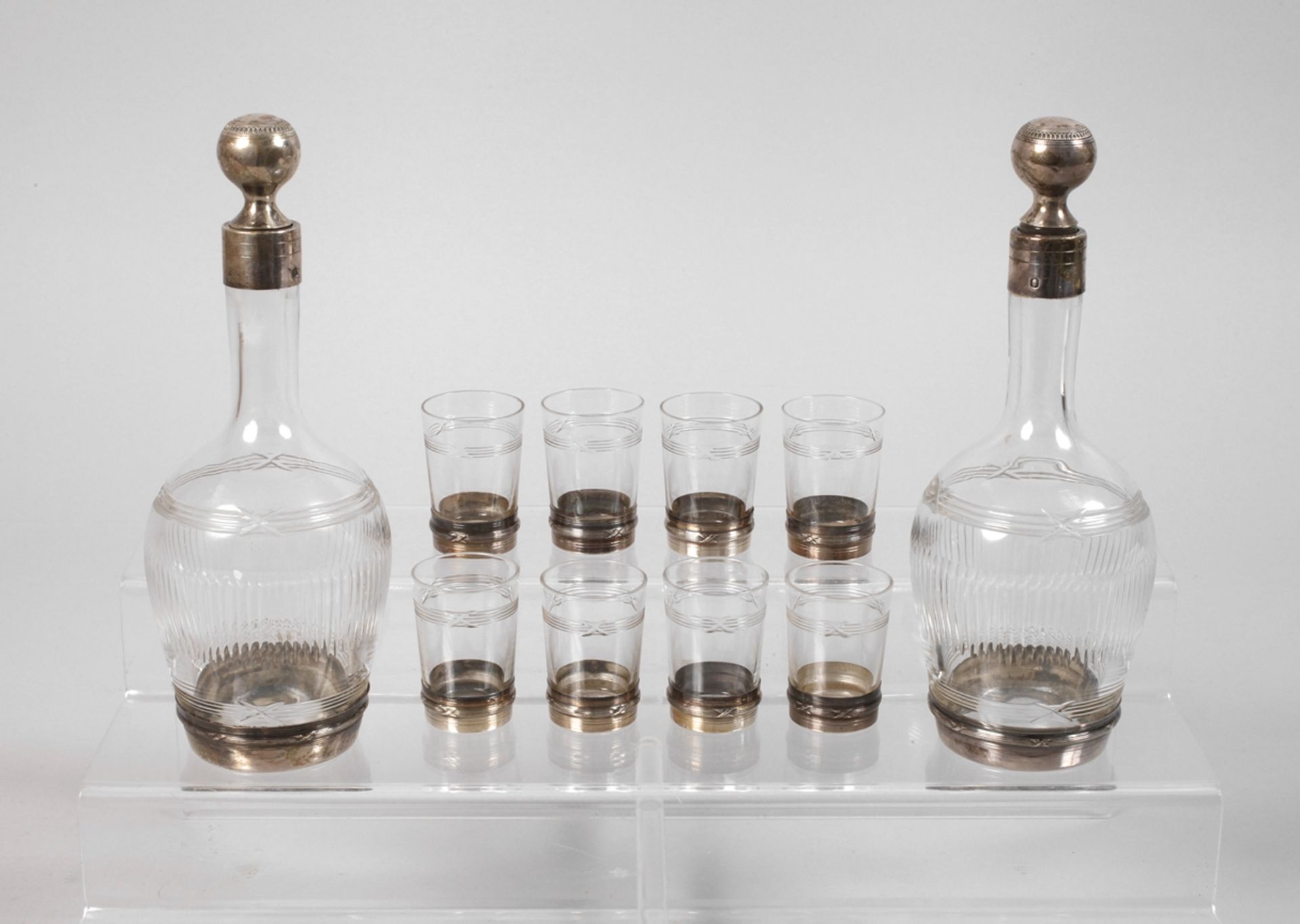 Two carafes and eight glasses with silver foot