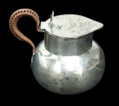 An Edwardian silver hot water jug, with hinged lid, wicker bound handle, William Comyns & Sons