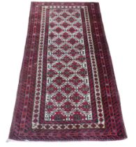 A 20th century Baluch woollen rug, with caucasian ground centre, red ground borders, 176 by 90cm.