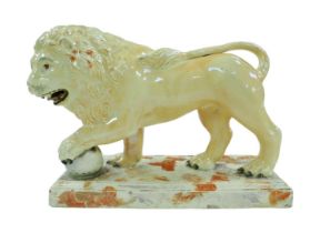 A 18th century or later Staffordshire figurine modelled as a Medici lion, with for paw resting