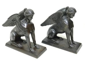 A pair of Victorian cast iron sculptures, modelled as sphinx figures, on rectangular bases,