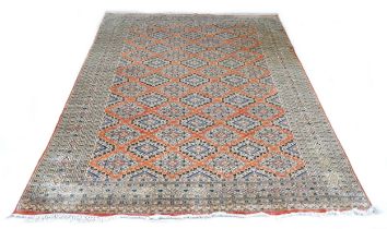 A hand knotted woolen rug with a pink field and geometric design, 302 by 224cm.