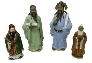 A group of four modern Chinese pottery figures, modelled as a man holding a scroll in pale blue