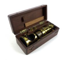 An early 20th century brass students field microscope in a mahogany box, box size 17cm by 7cm by