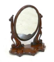 A Victorian mahogany toilet mirror, oval swing plate, shaped base, 67 by 31 by 80cm high.