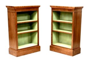 A pair of new walnut freestanding bookcases, each with two shelves and painted green internally,