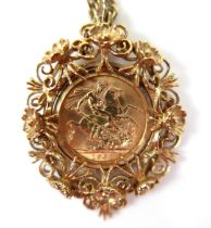 An Elizabeth II gold sovereign, 1963, mounted in a 9ct gold ornate floral and scrolling pendant