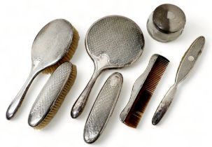 An Edwardian silver dressing table set comprising four brushes, tortoise shell comb, hand mirror and