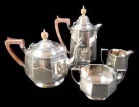 A George V silver four piece tea service, each of eight sided bellied form with decorative border to