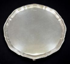 An Elizabeth II silver tray, with scalloped and cast bead edge, raised on three claw and ball