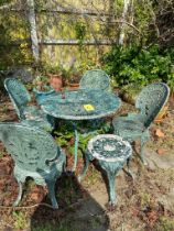 A green painted metal patio set, with four chairs, table, and stool.