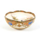 A Japanese Satsuma ware bowl, hand painted with two ladies in a garden