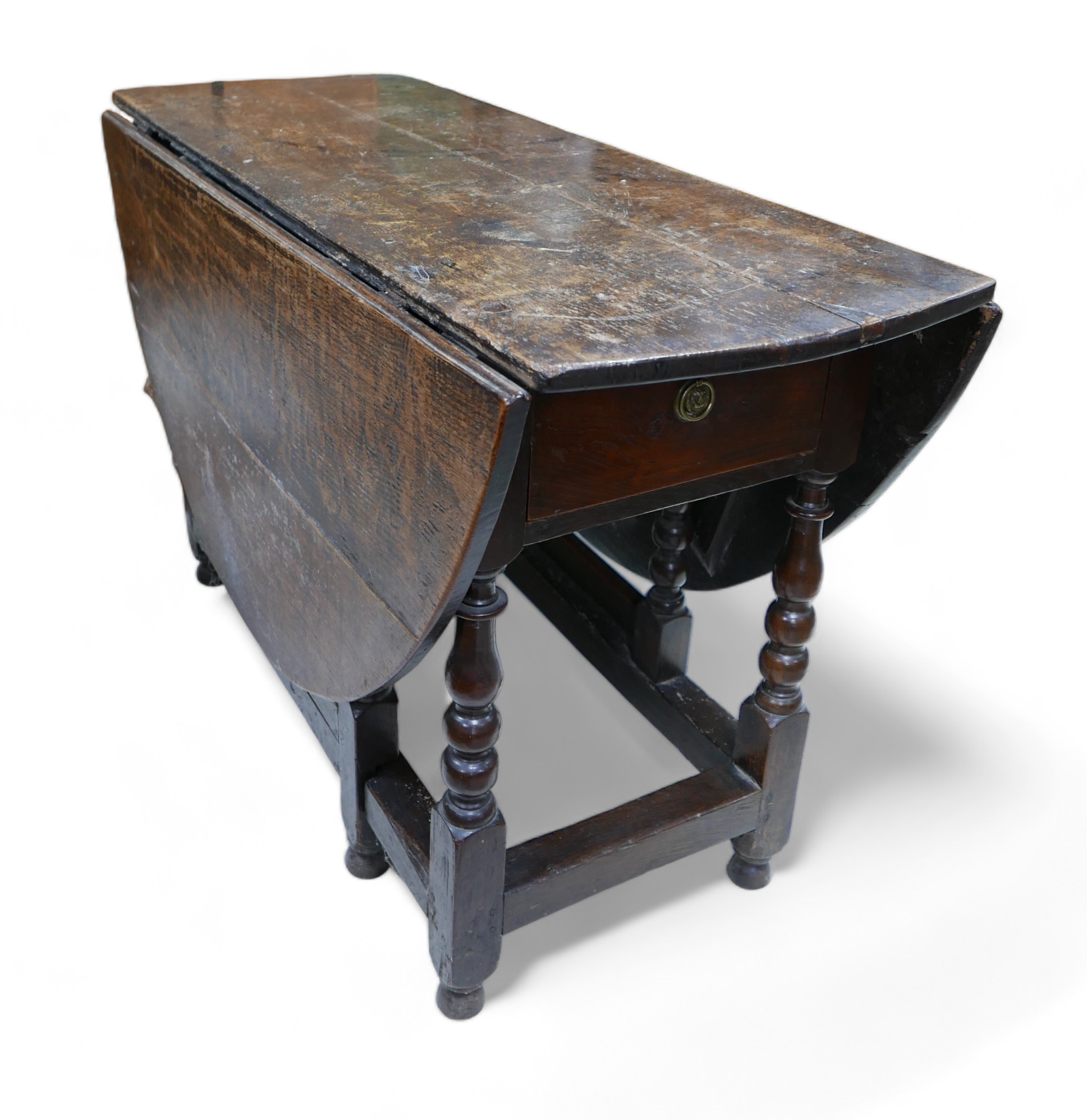 An 18th century oak drop leaf table, with oval top, two gate legs with turned supports and