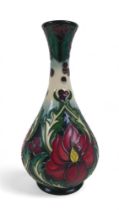 A Moorcroft tall neck vase, decorated with red flower and stylized green and white leaf details,