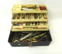 A collection of spoon and bait fishing lures contained in a folding case, including Shakespeare,