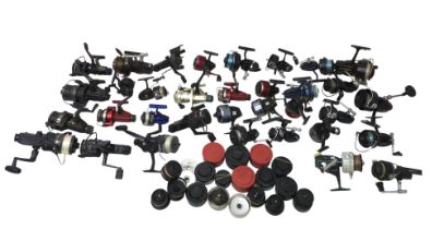 A collection of thirty three spool fishing reels including Shimano Triton Baitrunner, Cardinal