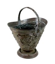 A Victorian copper fire basket, decorated with repousse face masks and scrolling foliage, 52cm high.