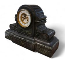 A Victorian black slate and marble drum mantel clock with exposed escapement, striking on a gong,