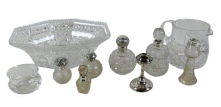 A group of silver topped cut glass bottles, three ovoid with silver tops, two and a vase with silver