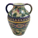 A twin handled pottery vase, decorated with flowers in buff, blue, green and pink colours, with