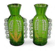 A pair of Victorian green glass vases, in Mary Gregory style, decorated with Lily of the Valley. (2)