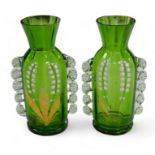 A pair of Victorian green glass vases, in Mary Gregory style, decorated with Lily of the Valley. (2)