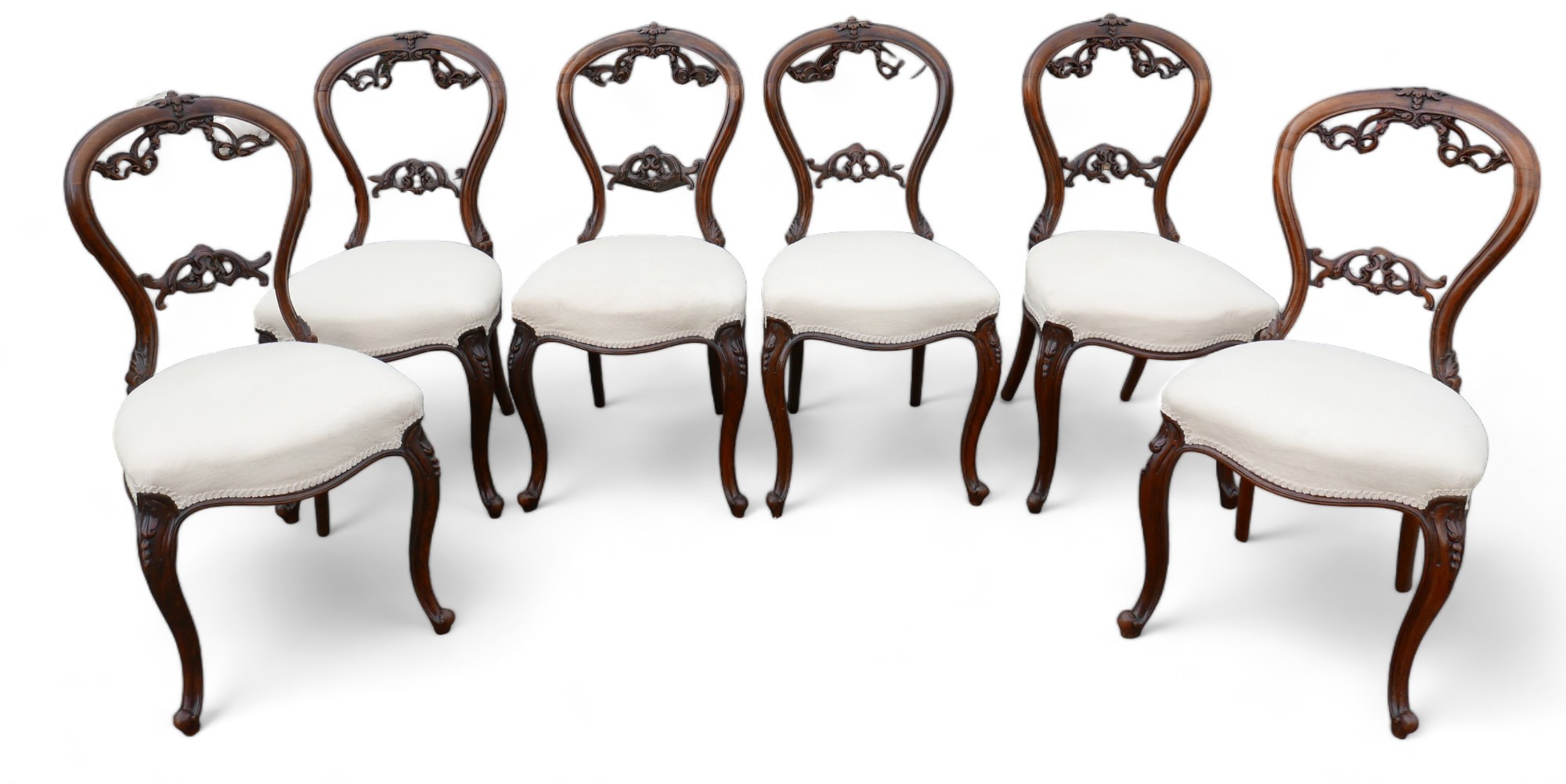 A set of six Victorian dining chairs, the balloon back and middle rail carved with foliage