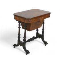 A Victorian burr walnut workbox with a fitted interior on turned pillar supports united by a