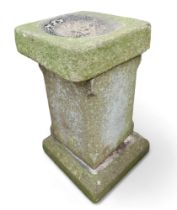 A stone bird bath, with square tapered column.