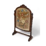 A Victorian walnut sugar barley twist fire screen with a needlework panel, 70 by 27 by 113cm tall.