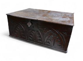A 17th century oak bible box, decorated with carved lunettes, iron hinges and lock plate.